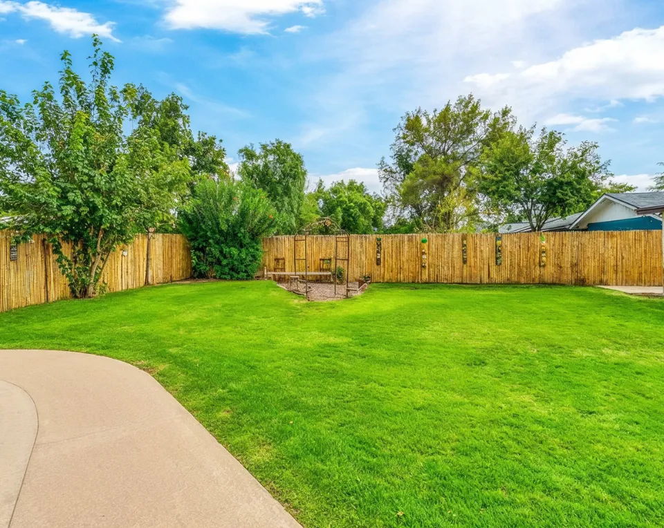 Empty backyard before patio construction in Los Angeles with grass lawn and wooden fence