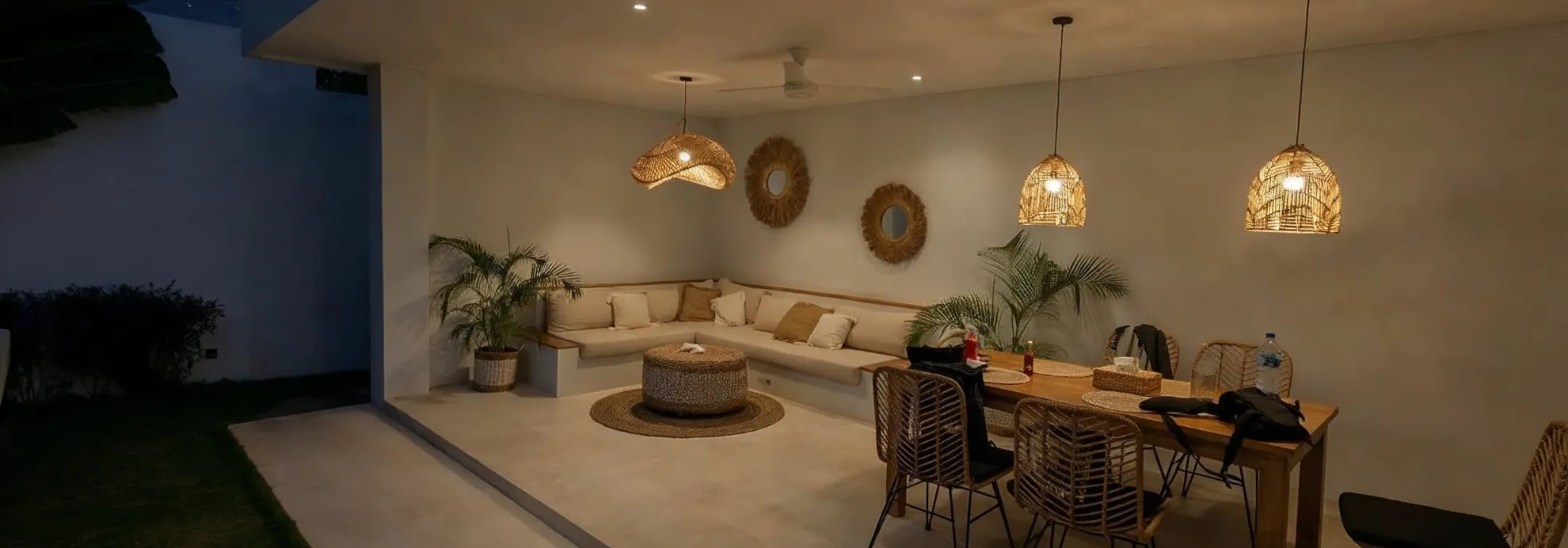 Outdoor living space in Los Angeles at night with warm lighting, covered patio seating, and modern design ambiance