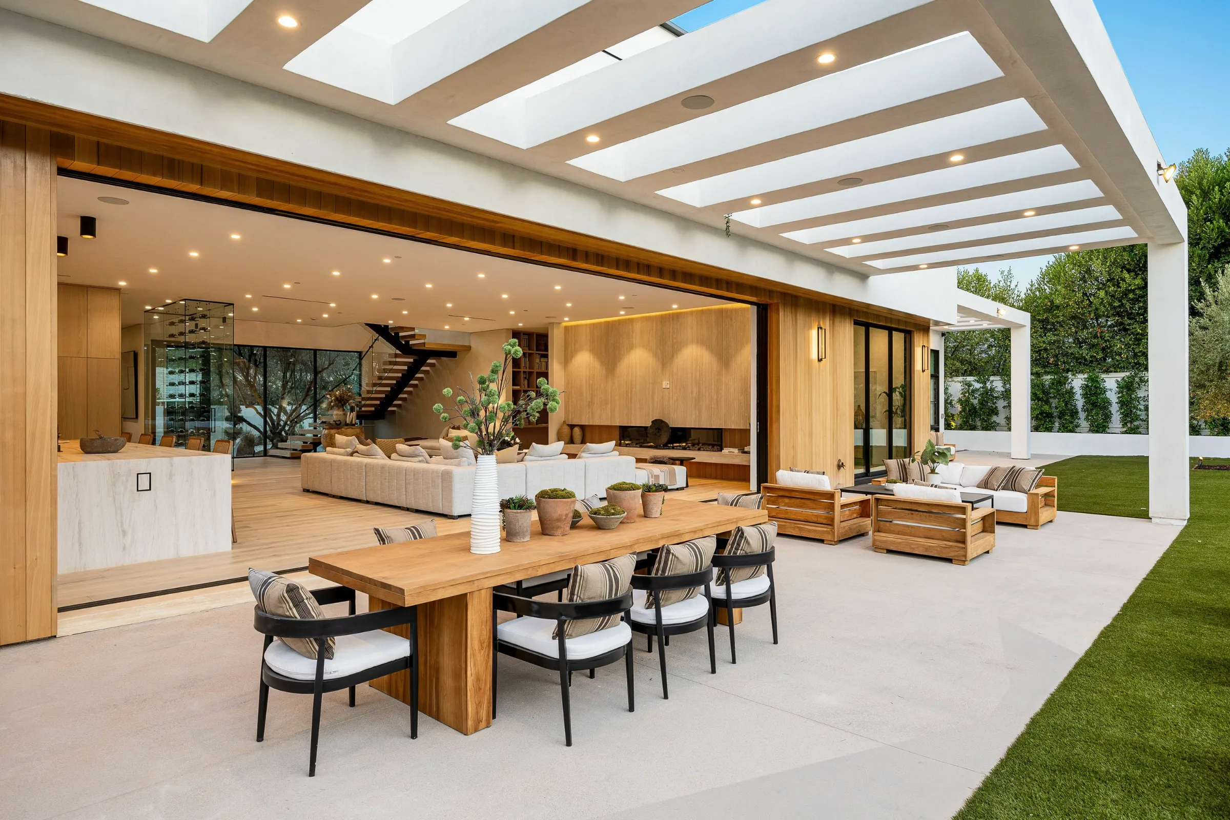Outdoor living space in Los Angeles with modern covered patio, dining area, lounge seating, and backyard pool design